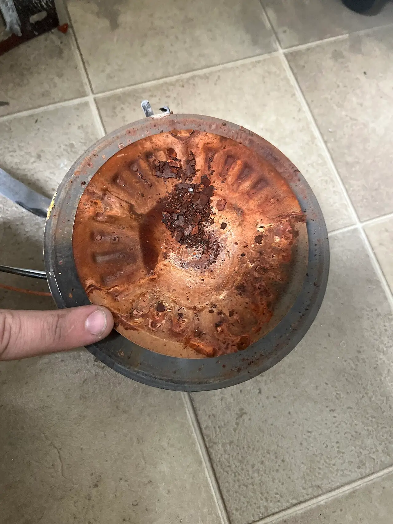 Rust and mineral sediment on a water heater's bottom plate