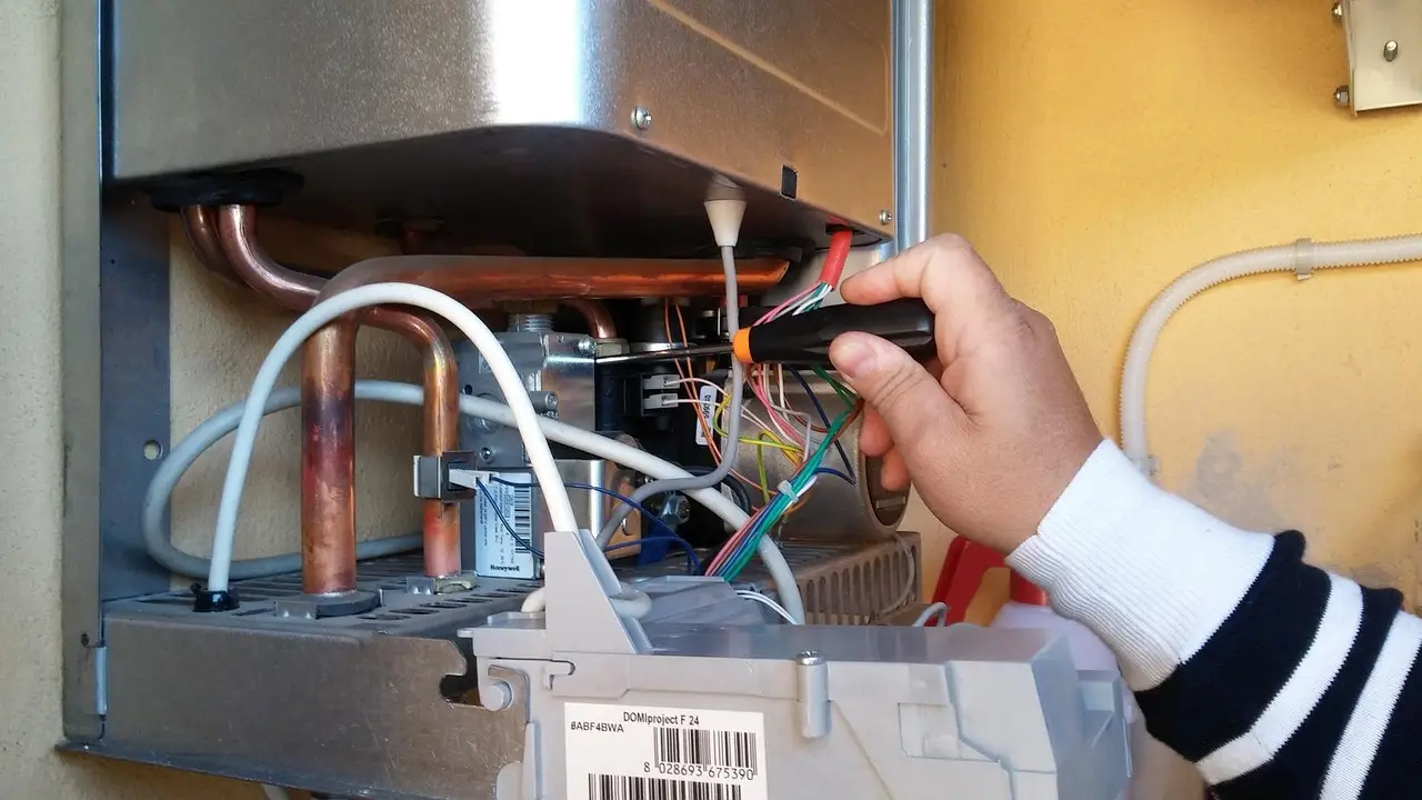 Technician repairing the internal controls of a water heater